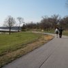 Paved lakeside path and benches at Lake Olathe in early spring